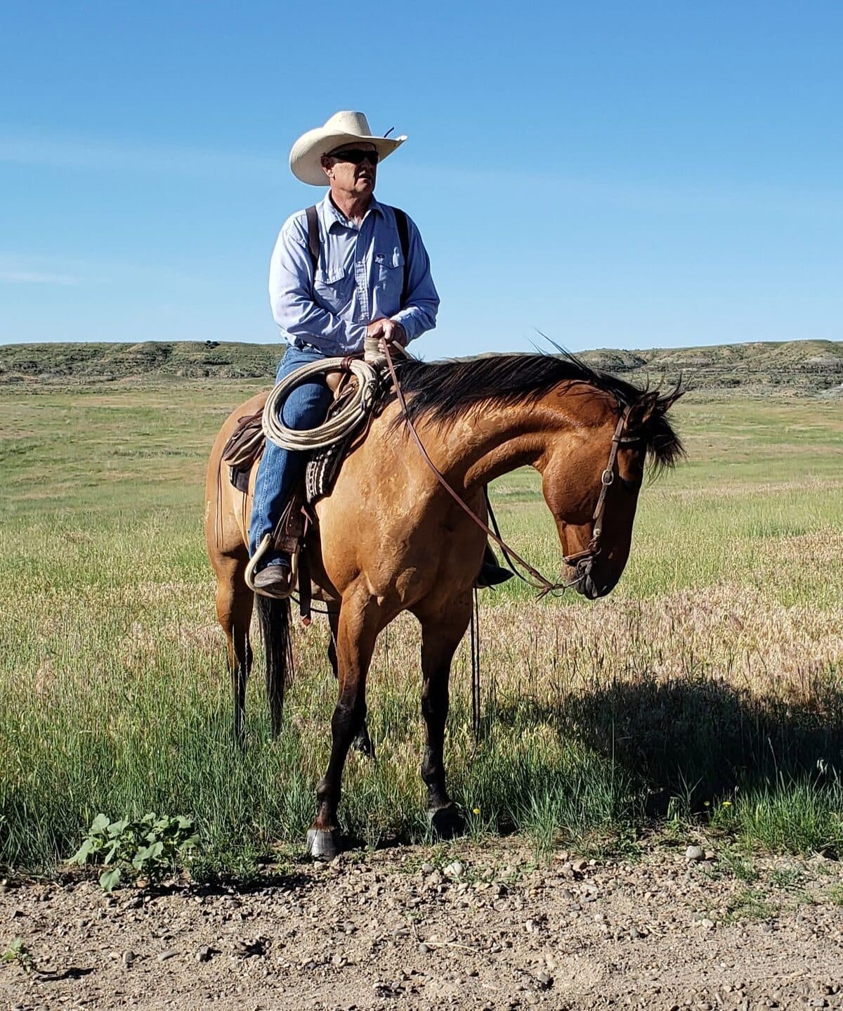 Pastor Arn on horseback with a rope on the saddle, on the prairie outside Miles City